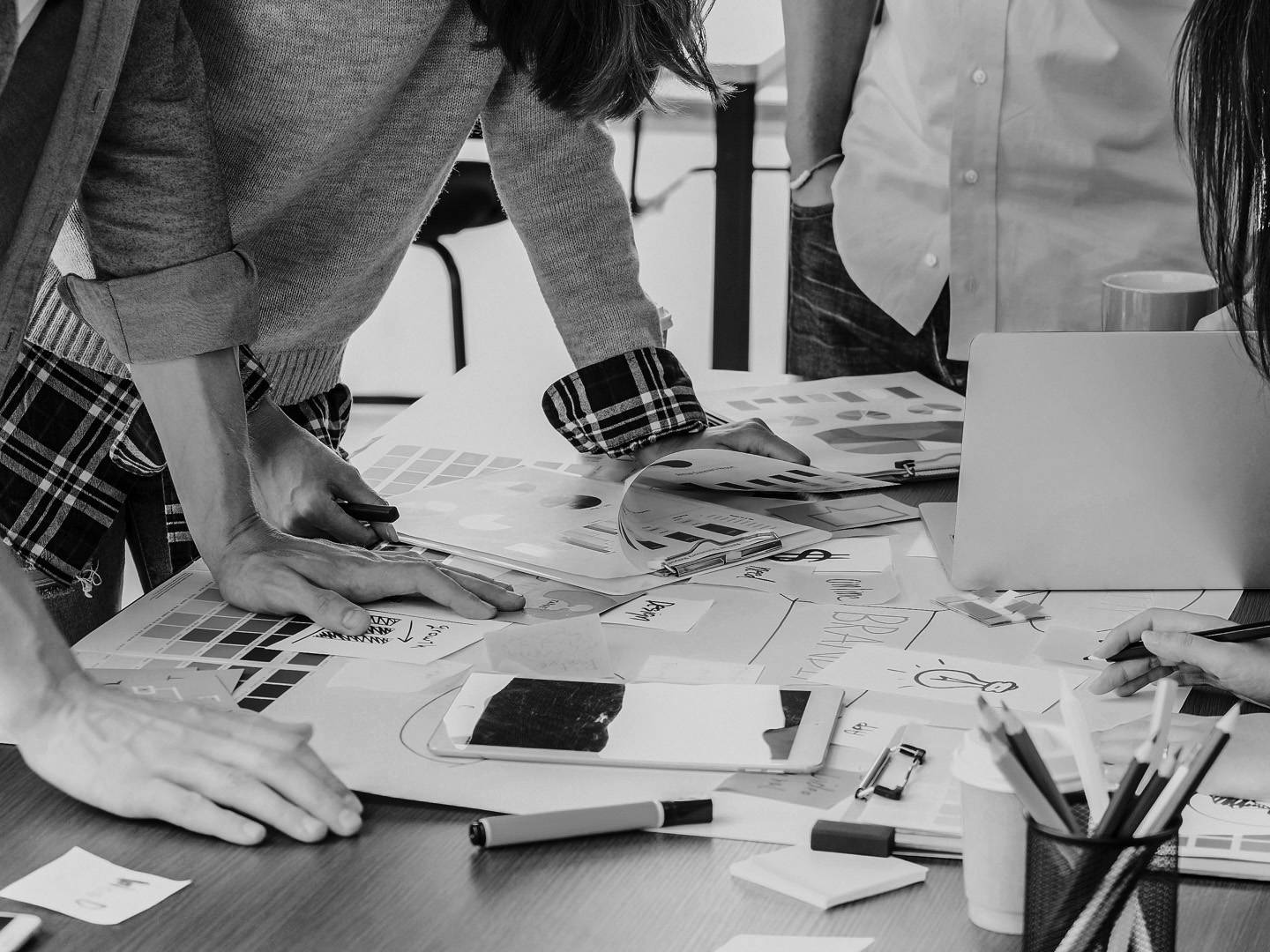 Creative team collaborating over printed materials during a marketing and design strategy session.