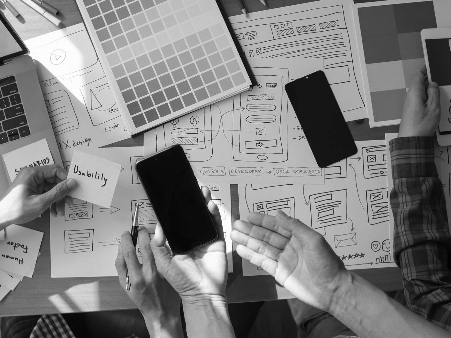 Creative workspace with colour samples, devices and design materials used for brand strategy development.