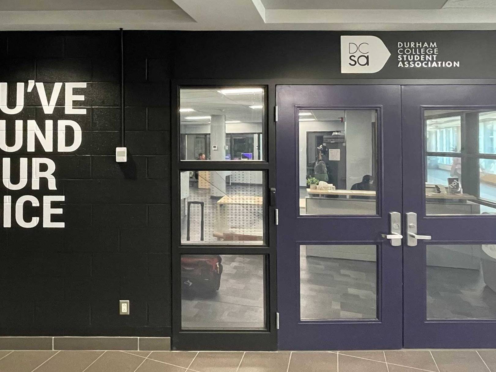 Branded office entrance featuring custom wall graphics and large-format environmental signage.