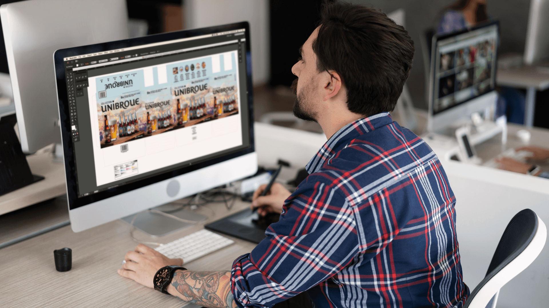Designer working at a computer on professional digital design and marketing projects.