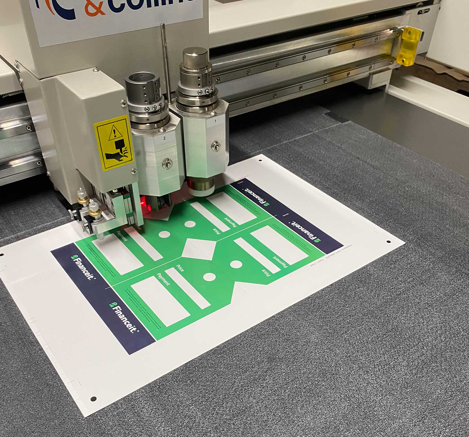 Financeit promotional tent cards being precision cut using commercial finishing equipment.