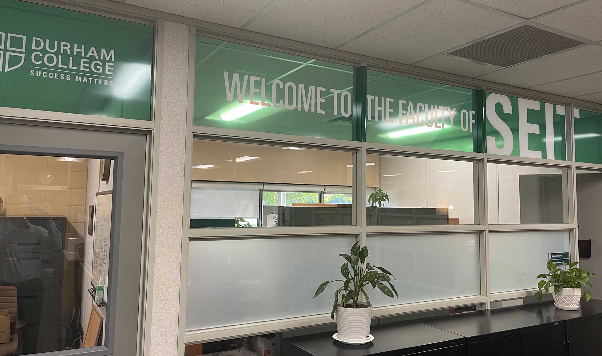 Corporate interior featuring custom large-format wall graphics and branded directional signage.