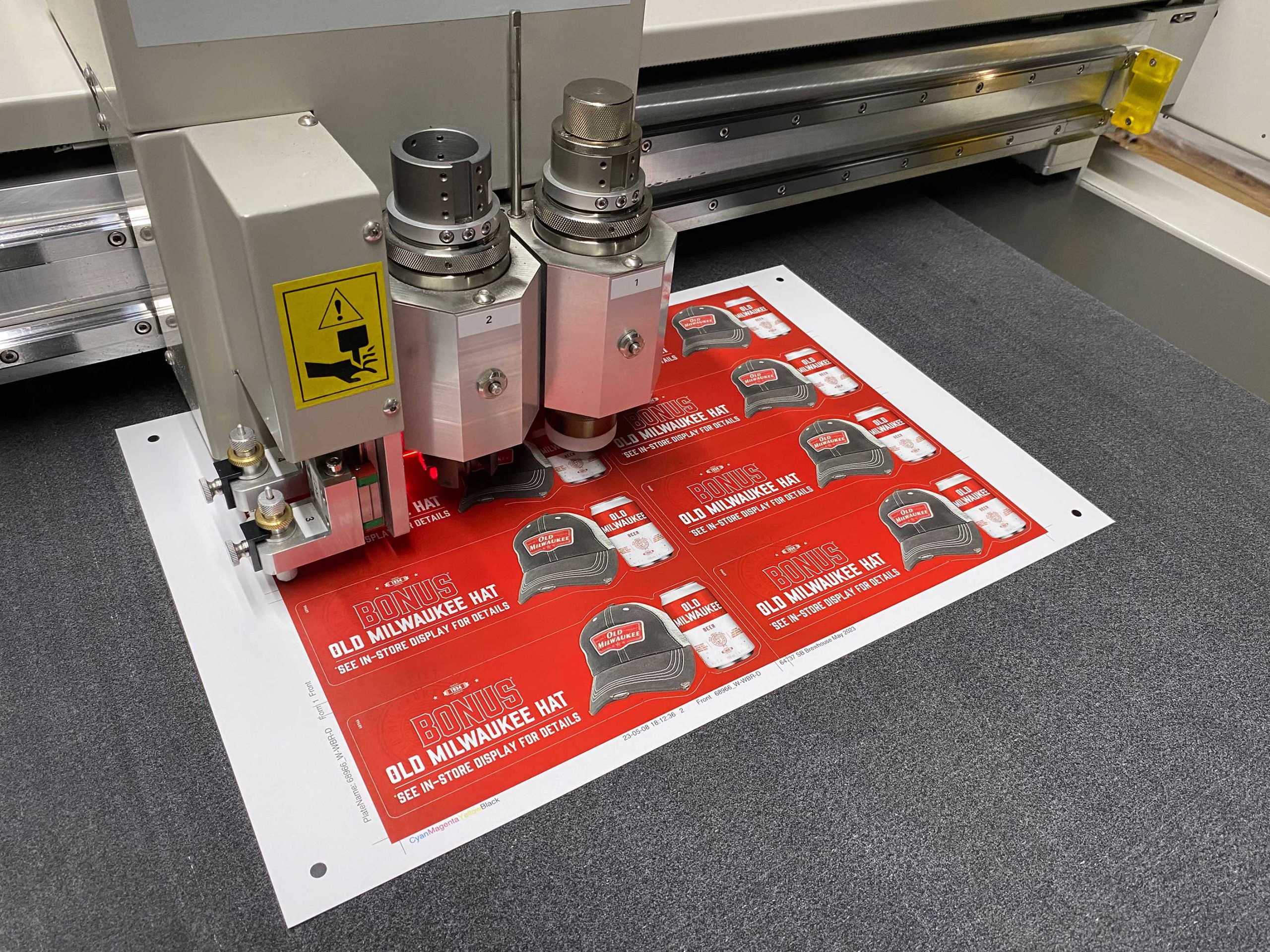Printed promotional materials being precision cut using automated digital finishing equipment.
