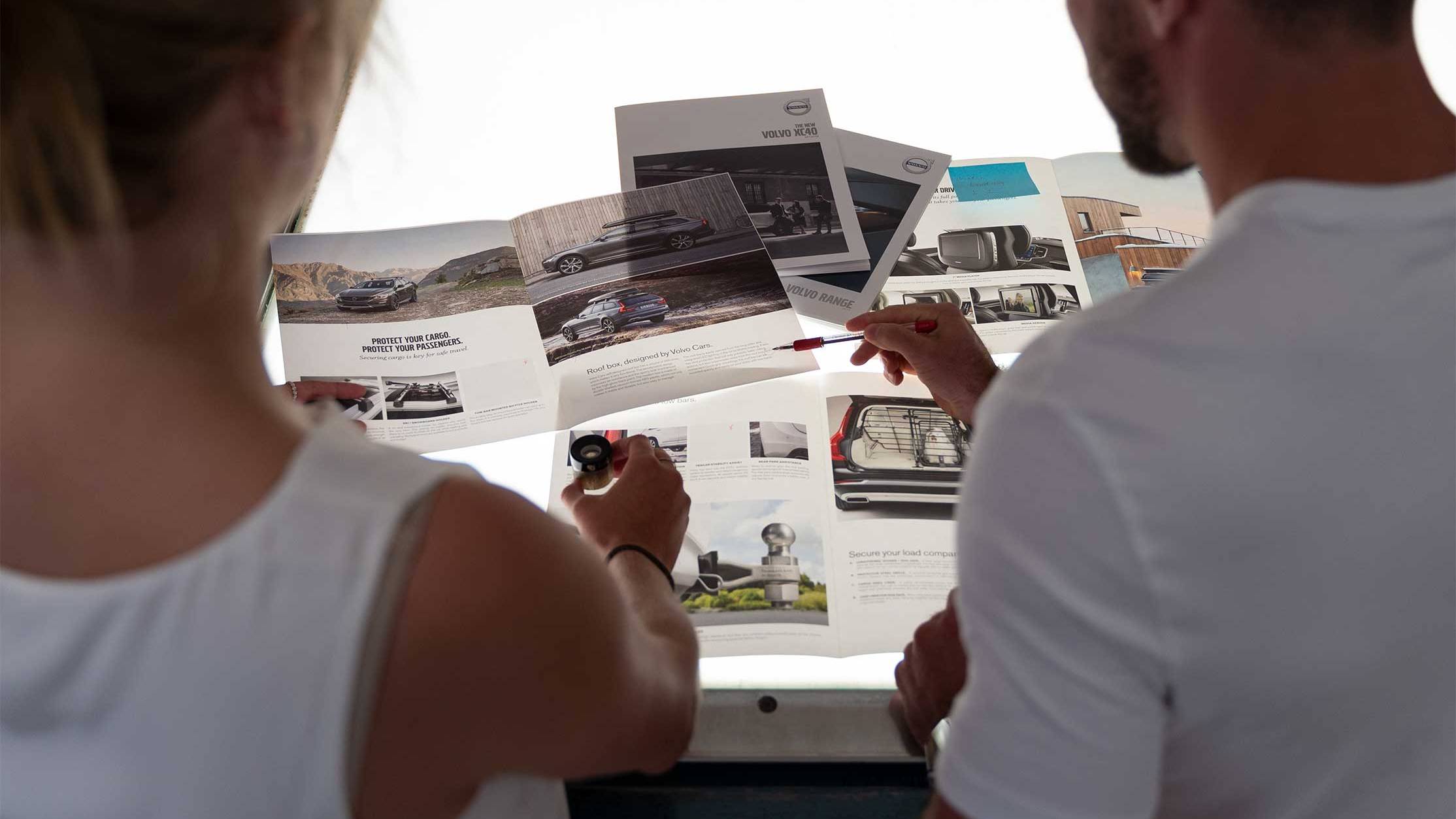 Creative professionals reviewing print samples and project materials during a collaborative production meeting.