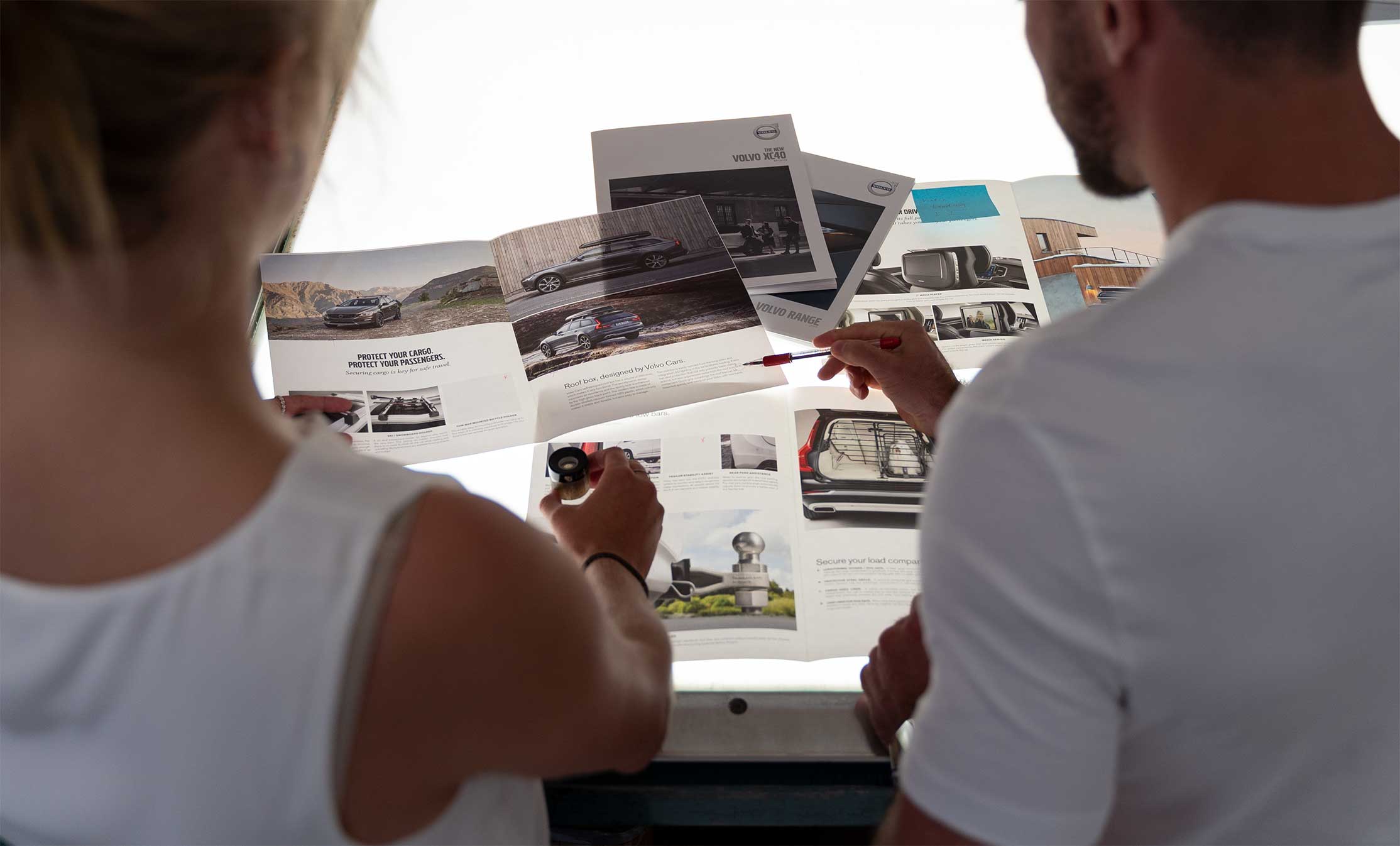Creative professionals reviewing print samples and project materials during a collaborative production meeting.