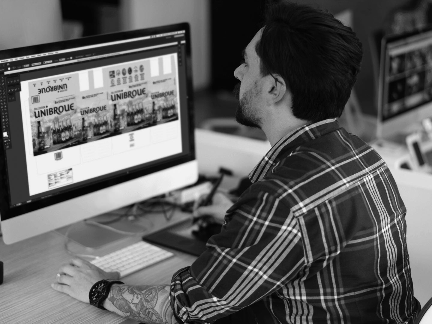 Designer working at a desktop computer on a professional digital creative project.